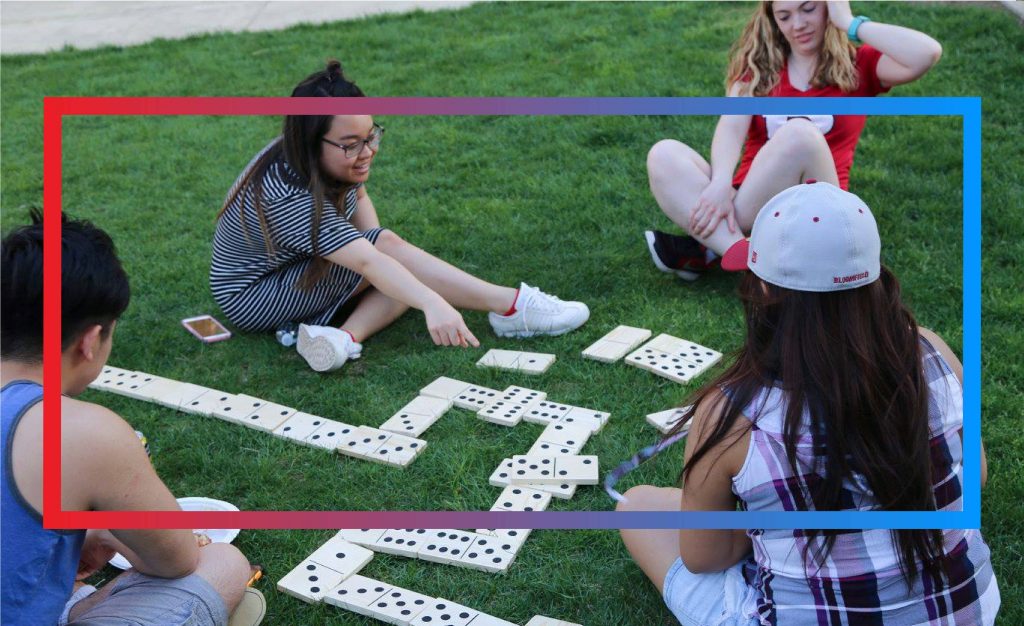 Students playing cards on the grass